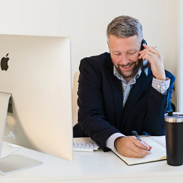an image of Andy McQuade on the phone taking notes